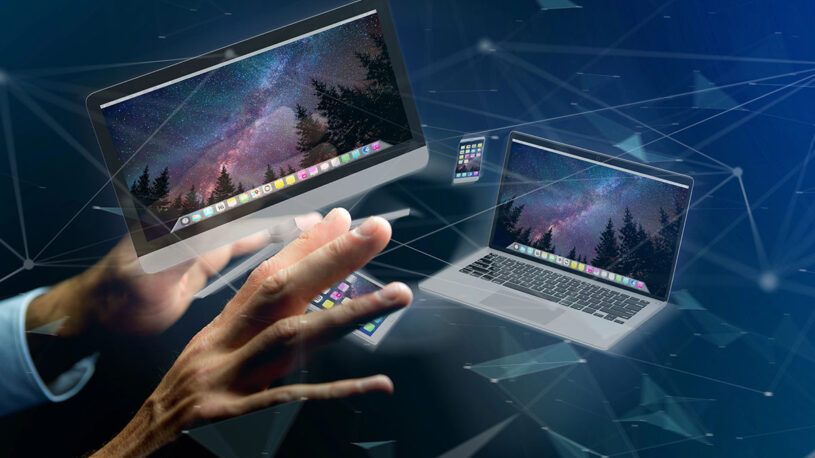 A futuristic digital illustration featuring a hand reaching toward multiple floating computer screens displaying a starry night sky, with geometric lines and shapes representing connectivity and technology.
