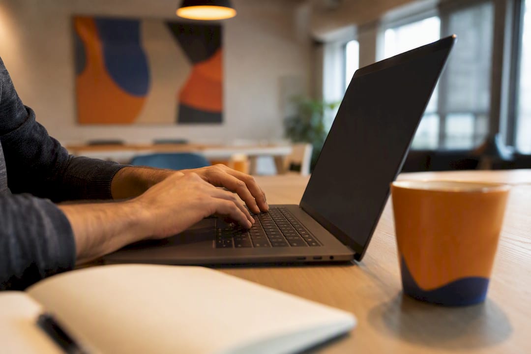 Hands typing on keyboard in home office