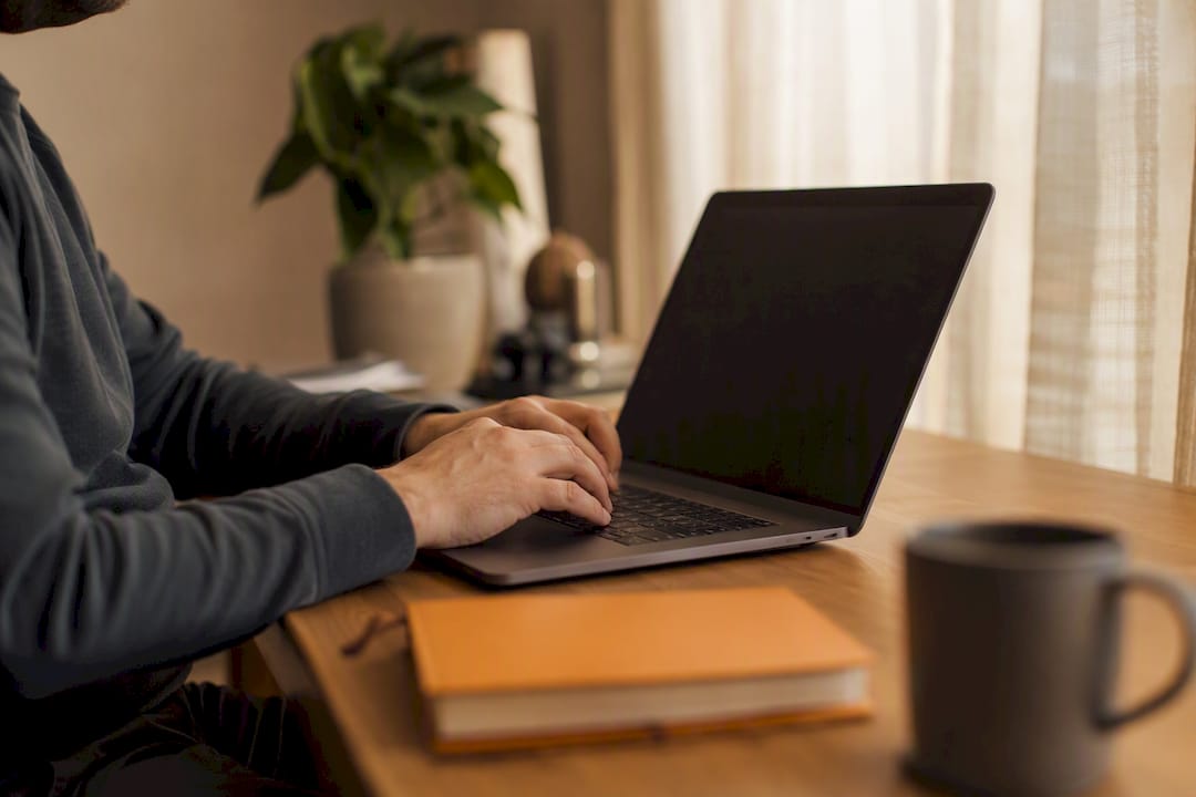 Hands entering business details on laptop