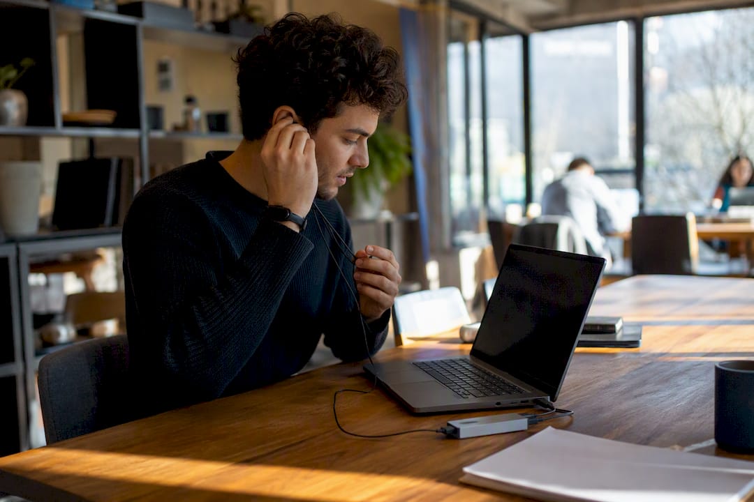 Hands plugging wired headset for AI customer service setup